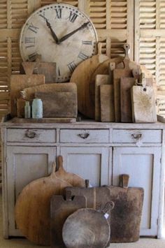 an old dresser with various items on it and a large clock in the back ground