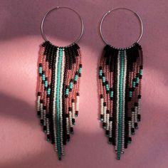 two pairs of hoop earrings with beaded fringes and beads on top of each other