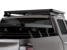 the back end of a silver truck with a black roof rack