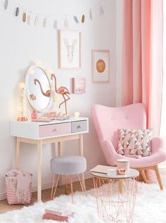 a room with pink furniture and pictures on the wall, including a vanity table and chair