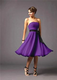 a woman in a purple dress posing for the camera