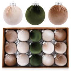 an assortment of christmas ornaments in a box with white, green and brown balls on top