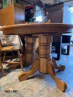 a wooden table sitting in the middle of a room next to a dresser and chair