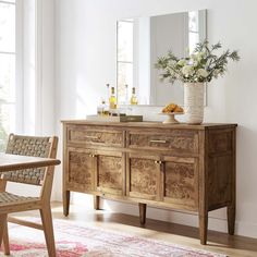 a wooden dresser sitting on top of a hard wood floor next to a table and chair