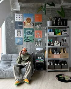 a man sitting on top of a couch next to a book shelf