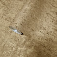 a roll of brown paper sitting on top of a wooden floor next to a wall