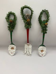 three green and red christmas spoons decorated with pine cones, wreaths and bells