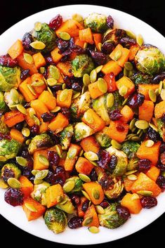 a white plate topped with brussel sprouts and sweet potatoes