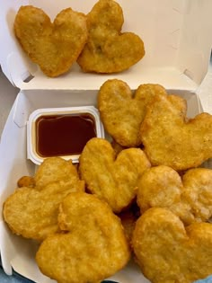 two takeout boxes filled with heart shaped fried food