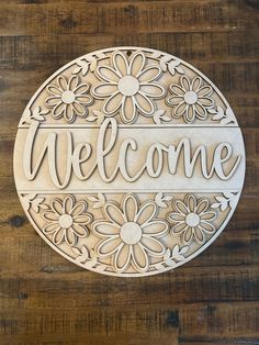 a wooden sign that says welcome with flowers on it