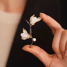 Why We Made This Crafted with meticulous attention to detail, this stunning piece captures the delicate beauty of magnolia blossoms in full bloom. Symbolizing beauty, grace, and resilience, the magnolia flower serves as a timeless emblem of strength and femininity. Wear this brooch as a reminder of your own inner beauty and the power of resilience. Product Details MADE FROM Brass, Zircon, Freshwater Pearl, Serpentine MEASUREMENTS Brooch size : 45 x 60mm / 1.8'' x 2.4'' TURN AROUND 2-3 days CARE Nancy Meyers, Magnolia Blossom, Floral Brooch, Delicate Beauty, Magnolia Flower, In Full Bloom, Inner Beauty, Flower Brooch, Summer Camp