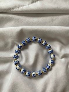 This elegant blue and white flowered ceramic bracelet brings color and style to go with any bracelet or watch you have on Blue Bead Bracelet Ideas, Whimsical Blue Bracelets For Gifts, Ceramic Bracelet, Trendy Blue Flower Bracelet, Handmade Blue Flower Beaded Bracelets, Handmade Flower Shaped Blue Beaded Bracelets, Playful Handmade Blue Bracelet, Blue Pottery Designs, Casual Blue Flower-shaped Beaded Bracelets