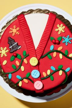 a cake decorated with buttons and decorations on a white plate next to a yellow wall