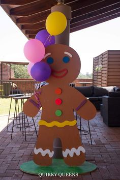 a cardboard ginger with balloons on it's head is standing in the middle of a patio