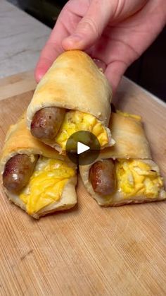 a person is making breakfast sandwiches with sausages and eggs in the shape of pita bread