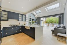 an open kitchen and living room with skylights