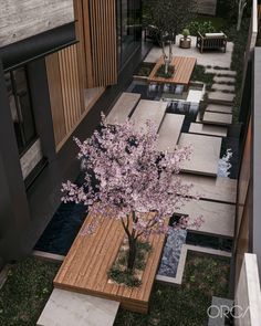 an aerial view of a tree in the middle of a courtyard with benches and tables