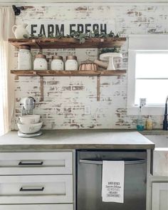 an old brick wall in a kitchen with open shelving above the dishwasher