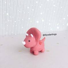 a small pink toy elephant with white tusks