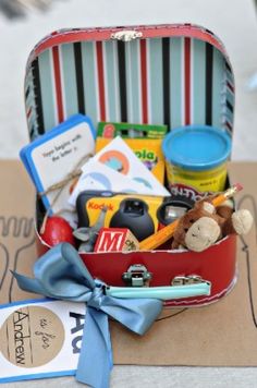 an open suitcase filled with toys on top of a wooden table next to a tag