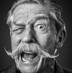 an old man with a moustache on his face is making a funny face