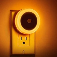 a yellow light switch with a black and white object on it's side next to the wall