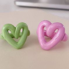 two rings shaped like hearts sitting on top of a table