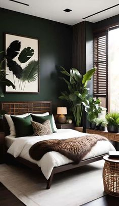 a bedroom with dark green walls, white bedding and large plants in the corner