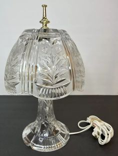 a glass table lamp with a cord plugged into it