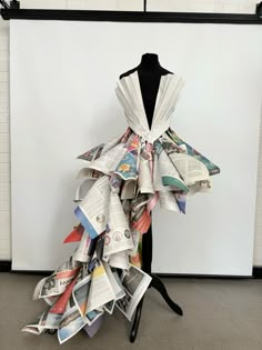 a dress made out of newspapers sitting on top of a mannequin