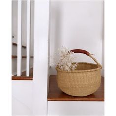 a basket sitting on top of a wooden shelf next to a banister stair case