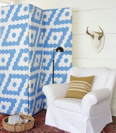 a room divider with blue and white designs on it, next to a chair