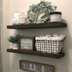 two wooden shelves with baskets and towels on them in a bathroom next to a toilet