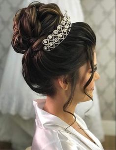 a woman wearing a tiara with pearls on it's head and her hair in a bun