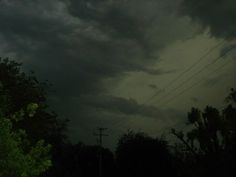 storm clouds over trees and power lines at night