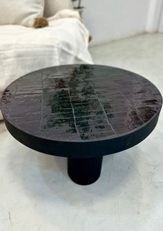 a round black table sitting on top of a white floor