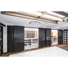 an empty room with black and white walls, shelving units, and wooden floors