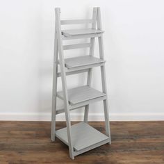 a white ladder shelf sitting on top of a wooden floor