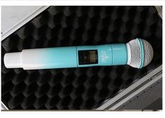 a blue and white microphone is in a black case with foam on the bottom part