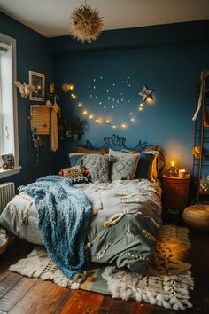 a bedroom decorated in blue and gold with lights hanging from the ceiling above the bed