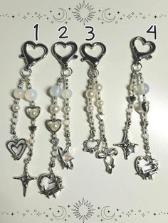 four different key chains with hearts and other charms hanging from them on a white background