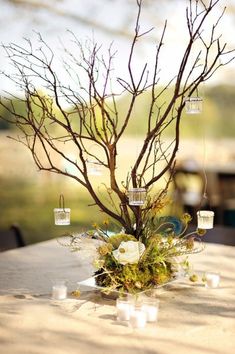 a vase with flowers and candles on top of a table