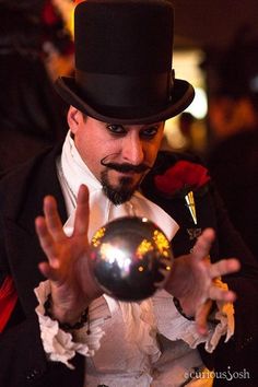 a man wearing a top hat and holding a ball