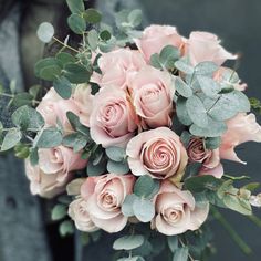 a bouquet of pink roses and eucalyptus leaves