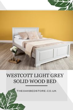 the westcott light grey solid wood bed is shown in this bedroom with yellow walls