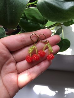 the tiny cherries are hanging from small gold - plated hooks, and have been crocheted to look like raspberries