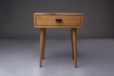 a small wooden table with two drawers on one side and an open drawer on the other