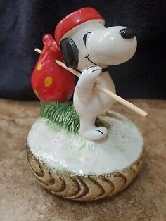 a figurine of a dog with a red hat and holding a baseball bat