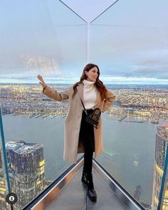 a woman standing on top of a tall building