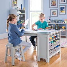 two children sitting at a table playing with toys